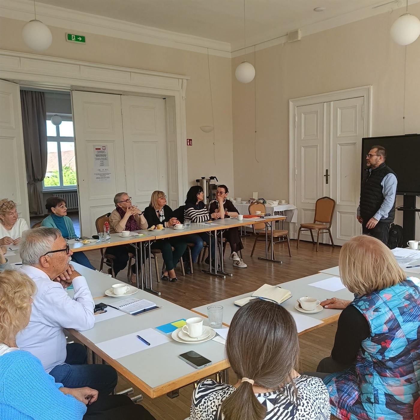 Spotkanie robocze przedstawicieli organizacji przy stołach konferencyjnych